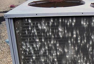 Image of what hail damage to the condener coils of a central air unit looks like. 