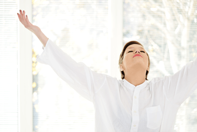 Woman taking a deep breath of fresh air in her home. AEM Mechanical Services, Inc. Hutchinson, MN 55350